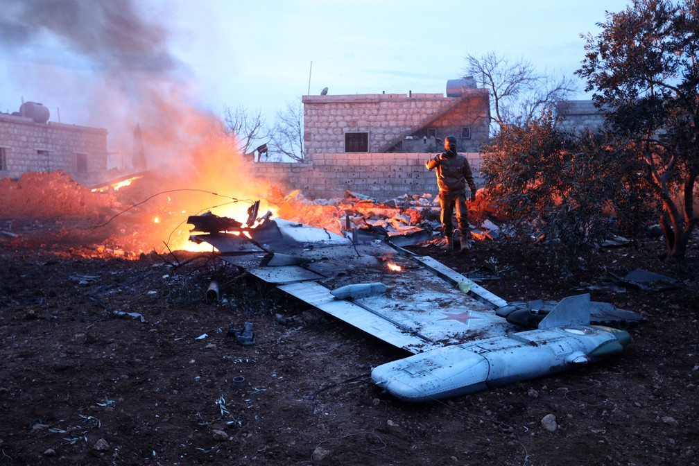 Rebelde sírio tira foto de destroços de avião russo que foi derrubado neste sábado (3) na Sìria (Foto: OMAR HAJ KADOUR / AFP)