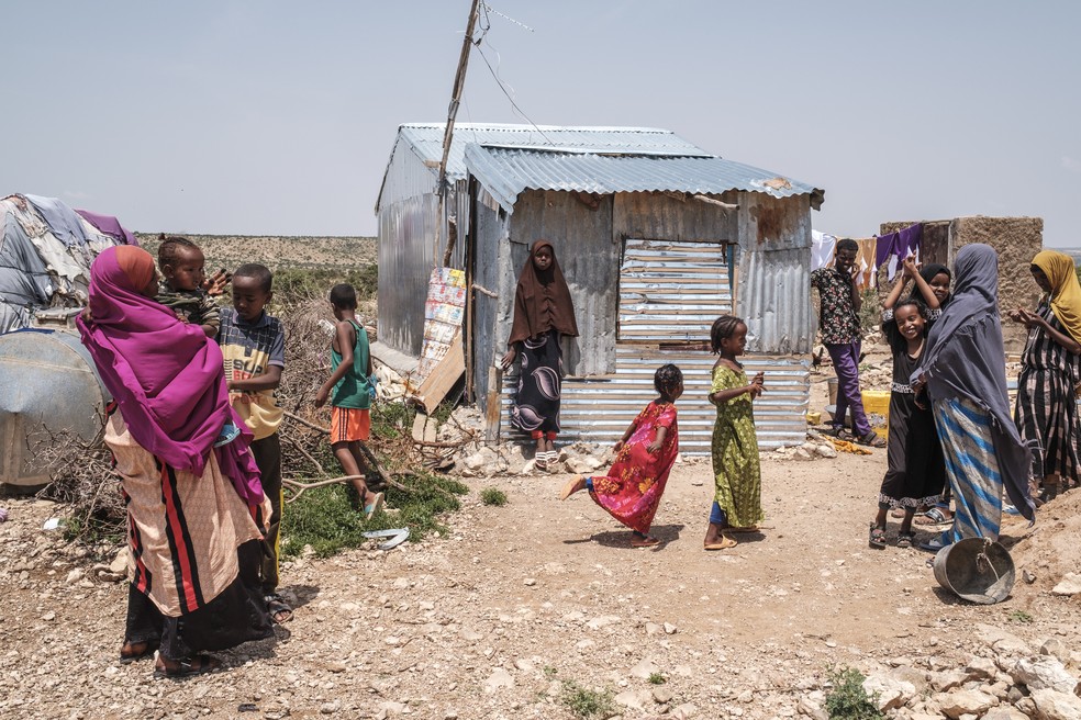 Pessoas do lado de fora de suas casas em um assentamento informal de deslocados internos nos arredores da cidade de Hargeisa, Somalilândia, em 16 de setembro de 2023. — Foto: EDUARDO SOTERAS / AFP