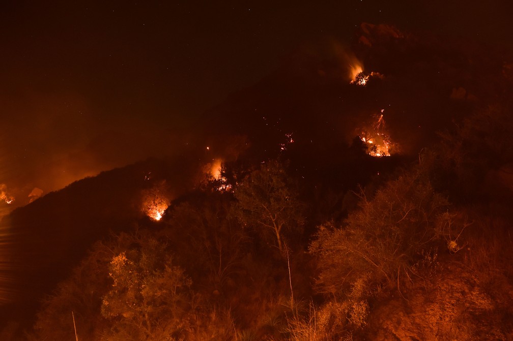 Focos de incêndio pontuais estavam nas colinas acima da Universidade Pepperdine, na região de Malibu, na Califórnia, na segunda-feira (13) — Foto: Robyn Beck / AFP