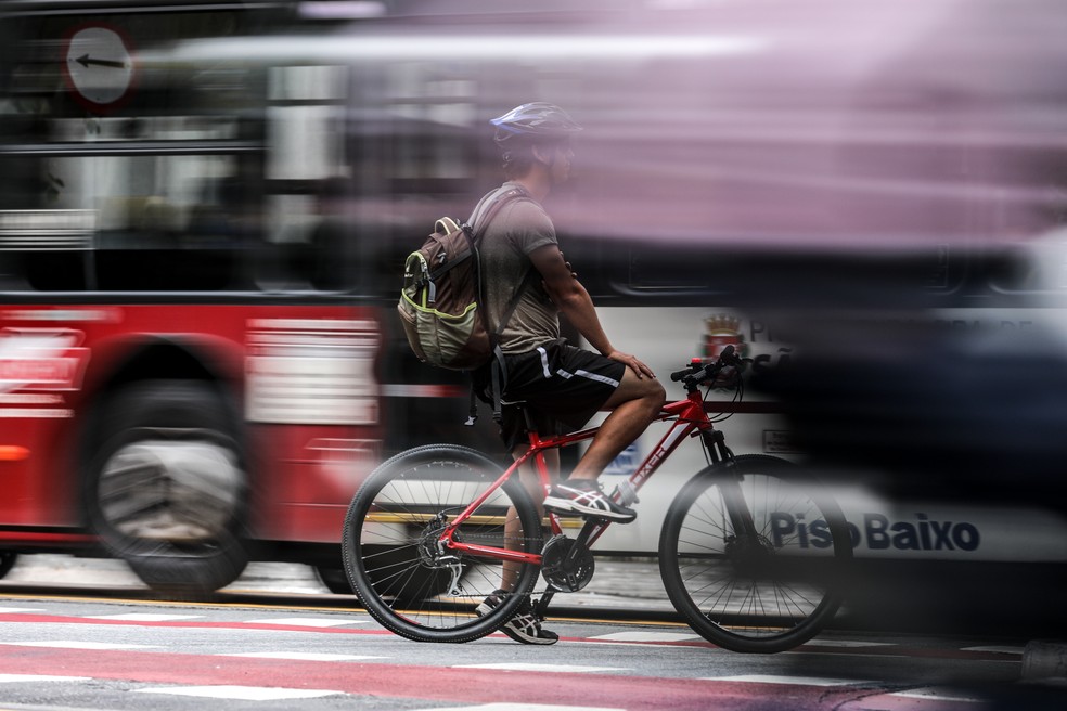 Ciclista é visto entre dois ônibus na ciclovia da avenida Engenheiro Luis Carlos Berrini, na zona sul de São Paulo — Foto: Marcelo Brandt/G1