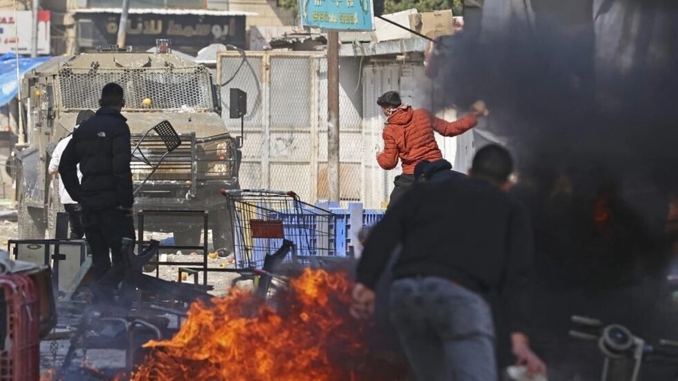 Jovens palestinos enfrentam ofensiva de soldados israelenses em Nablus. — Foto: AFP - ZAIN JAAFAR