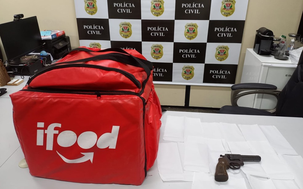 Bag de entrega e revólver encontrados na casa de suspeito de matar jovem em assalto — Foto: Polícia Civil/divulgação