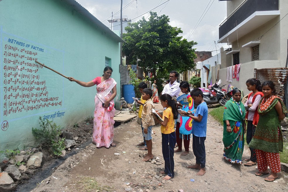Professores de vilarejo rural da Índia estão escrevendo lições nas paredes para driblar o fechamento das escolas devido à pandemia do coronavírus. — Foto: AFP
