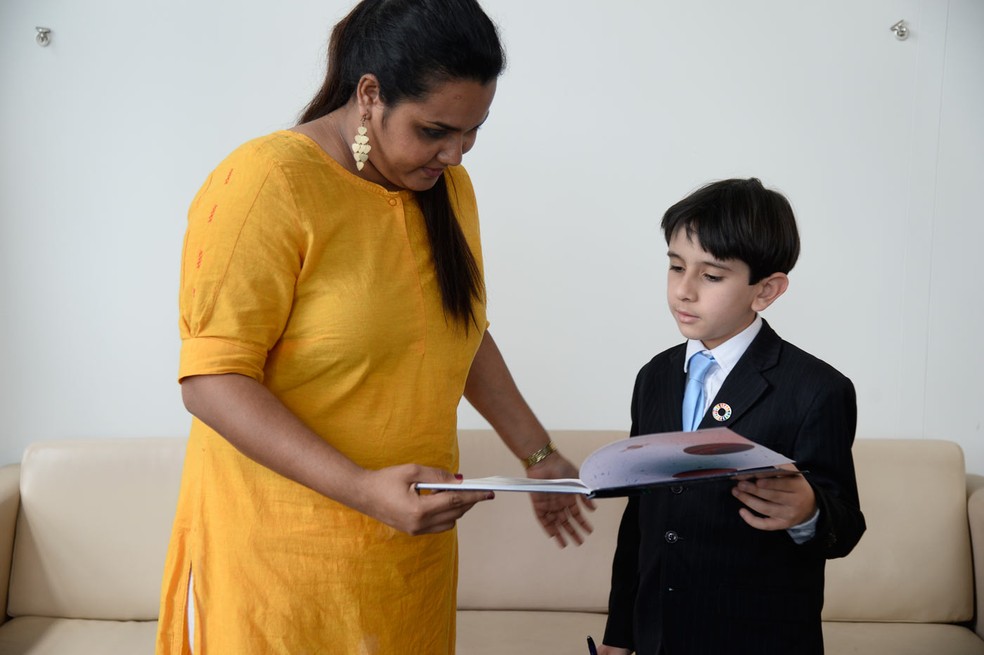 João Paulo Guerra Bezerra, brasileiro de oito anos, mostra um de seus livros publicados a Jayathma Wickramanayake, secretária geral da ONU para a Juventude, em Nova York (Foto: Divulgação/Fernanda Calfat)