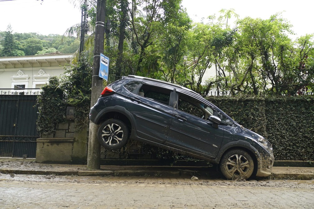 Carro foi arrastado pela água e parou escorado em um poste após a chuva em Petrópolis — Foto: Marcos Serra Lima/g1