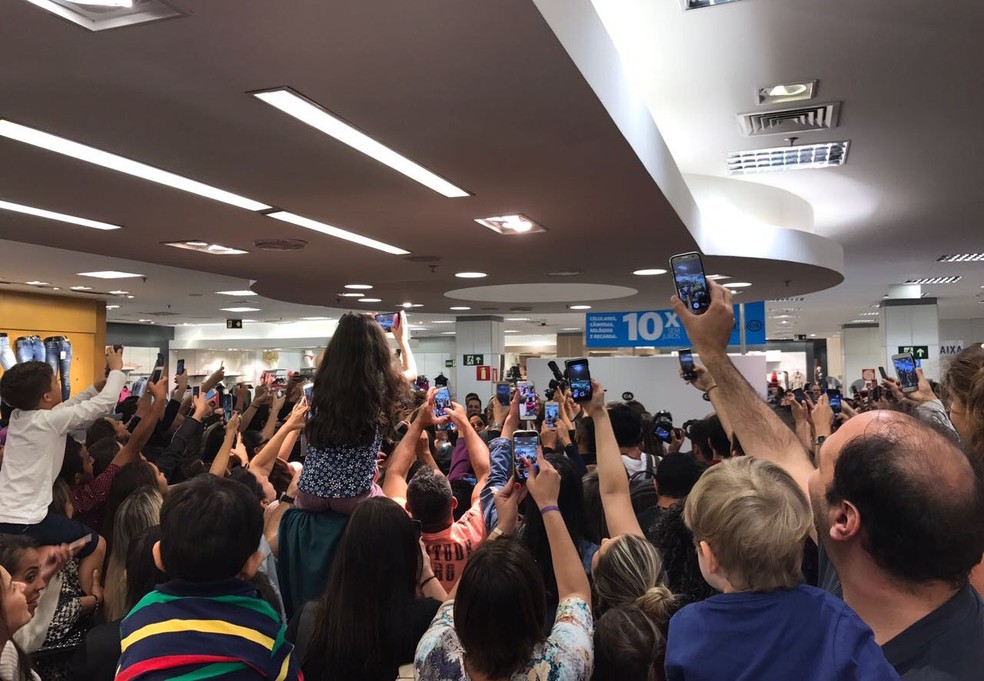 Anitta (no meio, de óculos, 'engolida' pelos fãs) chega de surpresa a shopping de BH. (Foto: Junior Marques/Divulgação)
