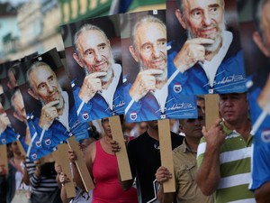 Pessoas seguram fotos de Fidel Castro durante a chegada da caravana que percorre o país com as cinzas do ex-presidente cubano em Las Tunas