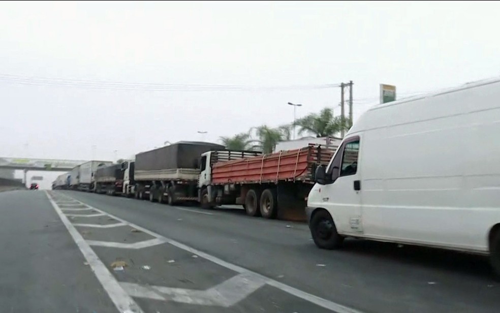 Caminhoneiros ocupam uma faixa e o acostamento da estrada na altura de Embu das Artes (Foto: GloboNews/Reprodução)