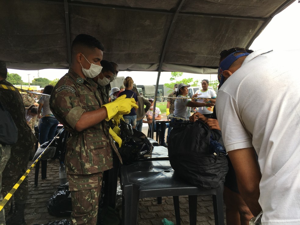 Militares revistam bagagens e pertences de venezuelanos que estavam acampados na praça Simón Bolívar (Foto: Emily Costa/G1 RR)