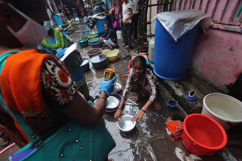 Profissional de saúde faz rastreamento de pessoas com sintomas de Covid-19 em Dharavi, uma das maiores favelas da Ásia, em Mumbai, na Índia, nesta segunda-feira (6)  — Foto: Rafiq Maqbool/AP 