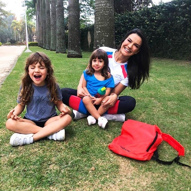 Kyra Gracie posa sorridente com as filhas, Ayra e Kyara, em jardim (Foto: reprodução/Instagram)