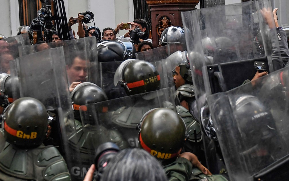 O líder da oposição e autoproclamado presidente da Venezuela, Juan Guaidó, confronta membros da Guarda Nacional Bolivariana ao chegar à Assembleia Nacional, em Caracas, na terça-feira (7) — Foto: Federico Parra/AFP
