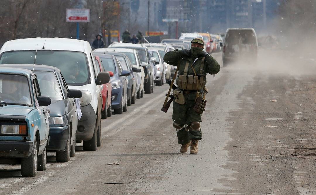 Soldados russos monitoram fila de carros para deixar Mariupol 