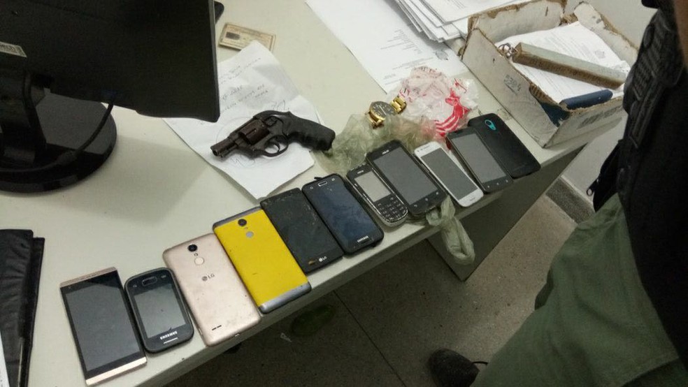 Com o trio foi encontrado um rev&oacute;lver calibre 38, um simulacro de pistola, 11 celulares e um rel&oacute;gio (Foto: Pol&iacute;cia Militar/Divulga&ccedil;&atilde;o)
