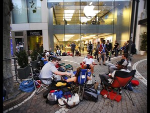 Fãs aguardam o lançamento dos novos modelos do iPhone em frente à uma loja da Apple em Frankfurt, na Alemanha (Foto: Michael Probst/AP)