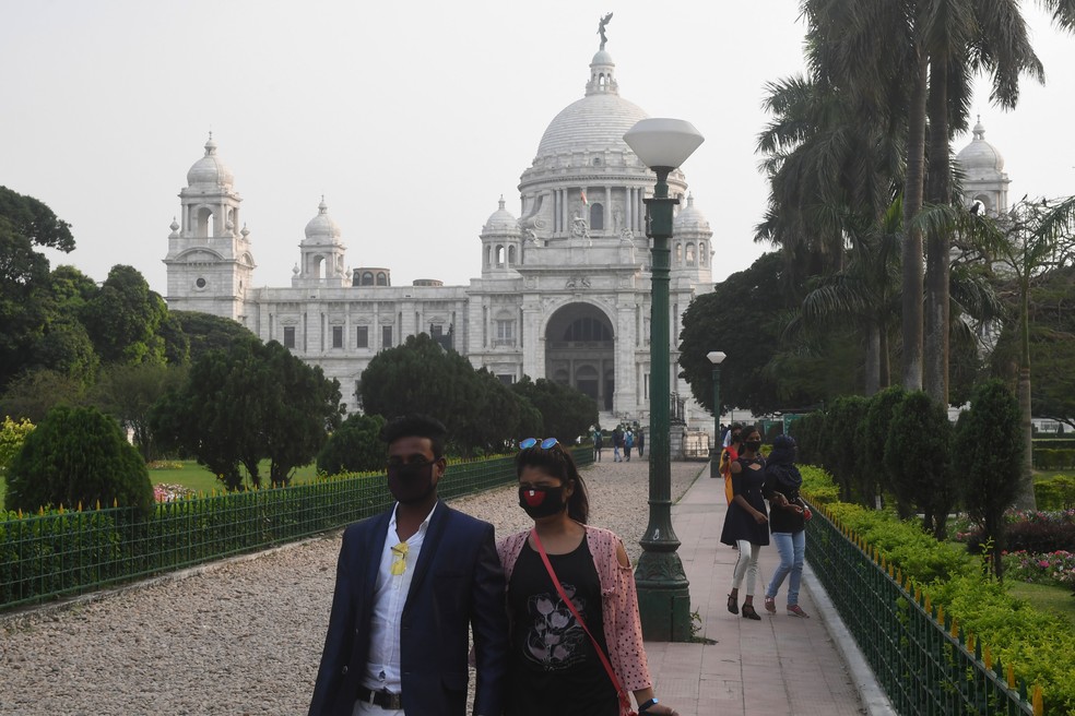 Turistas deixam Victoria Memorial em Calcutá, na Índia, nesta terça-feira (17) — Foto: Dibyangshu Sarkar / AFP