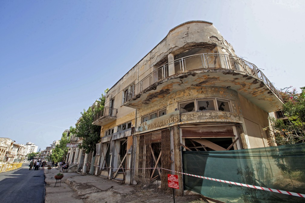 Prédios abandonados em Varosha, no Chipre, aparecem com cordão de isolamento na reabertura desta quinta-feira (8) — Foto: Birol Bebek/AFP