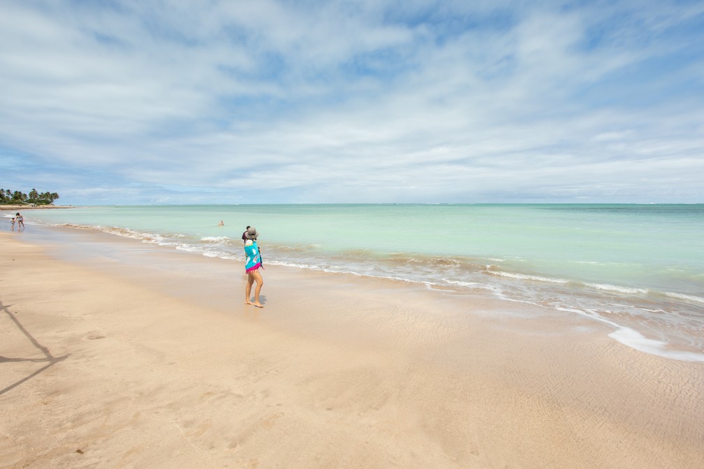 Turista caminha pela areia na Praia de Lages, em Porto de Pedras: balneário é destaque da Rota Ecológica dos Milagres — Foto: Celso Tavares/G1