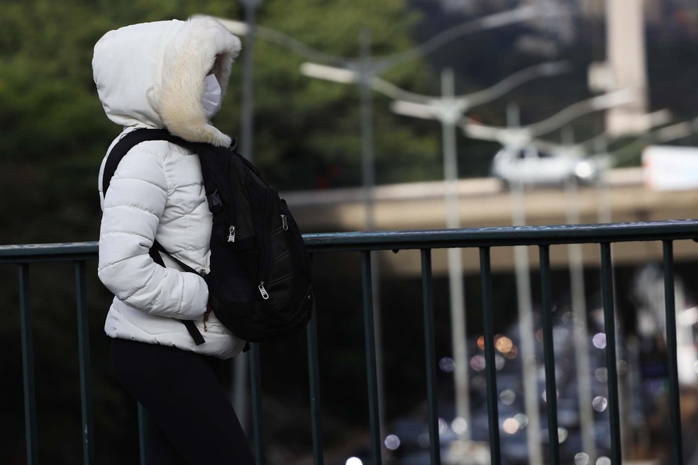 FRIO: Mulher caminha em viaduto na cidade de São Paulo, SP, nesta quarta feira, 18, durante frente fria.   — Foto: RENATO S. CERQUEIRA/FUTURA PRESS/ESTADÃO CONTEÚDO