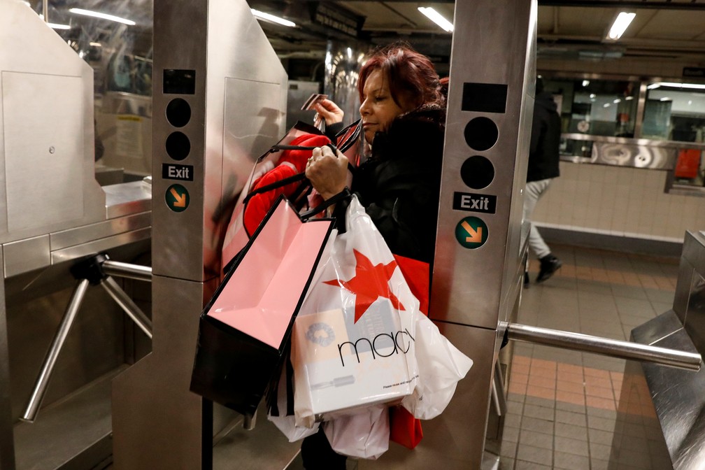 Consumidora entra no metrô em Nova York carregando as compras — Foto: Brendan McDermid/Reuters