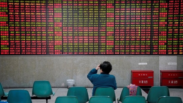 Investidor observa dados de ações em casa de corretagem em Xangai, na China - bolsa - ações - Ásia (Foto: Aly Song/Reuters)
