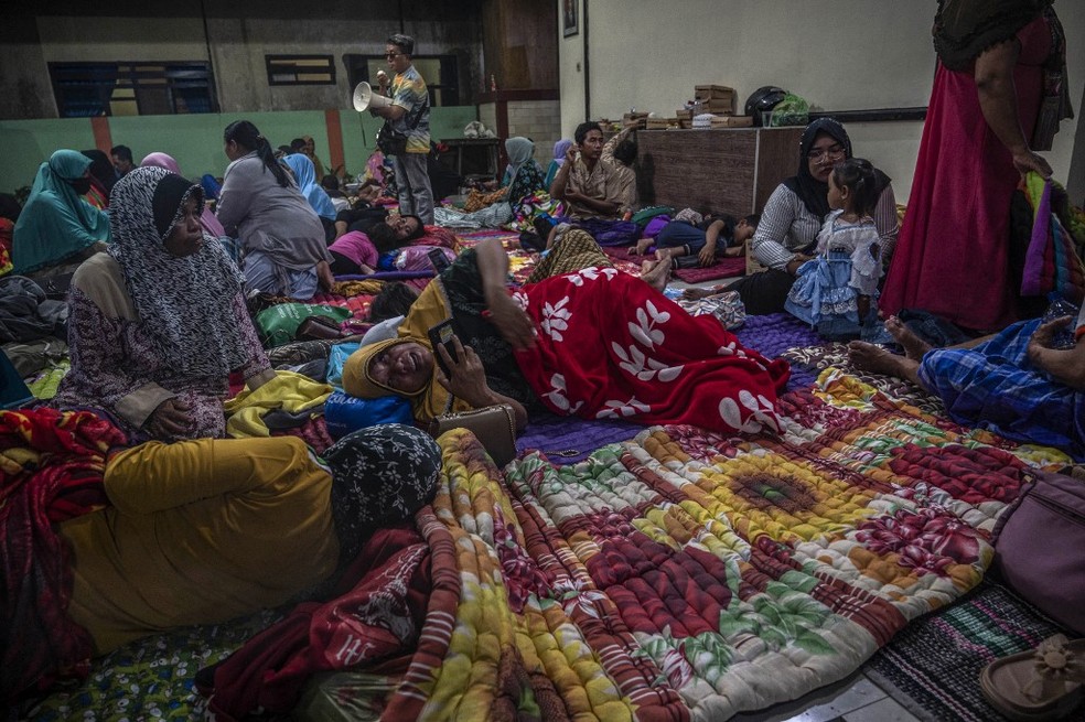 Foto de 4 de dezembro de 2022 mostra pessoas em abrigo temporário na vila de Candipuro, na Indonésia, depois da erupção do vulcão Semeru — Foto: Juni Kriswanto/AFP