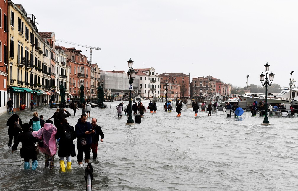 Pessoas caminham em Veneza apÃ³s inundaÃ§Ã£o atingir nÃ­vel recorde na segunda-feira (29). InundaÃ§Ã£o foi causada pela convergÃªncia da marÃ© alta e de fortes ventos  â Foto: Miguel Medina / AFP