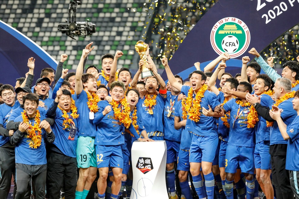 Jogadores do Jiangsu Sunning erguem o troféu do Campeonato Chinês — Foto: AFP
