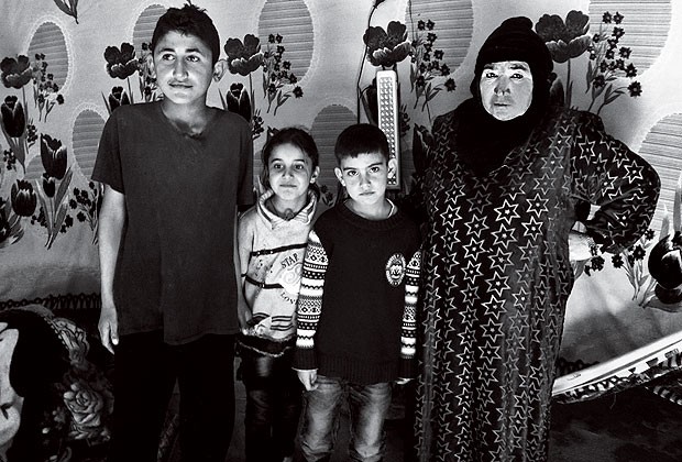 A síria Turkia Al Abudde vive com o marido e cinco filhos em uma barraca construída com lona plástica (Foto: Dubes Sônego e Yan Boechat)