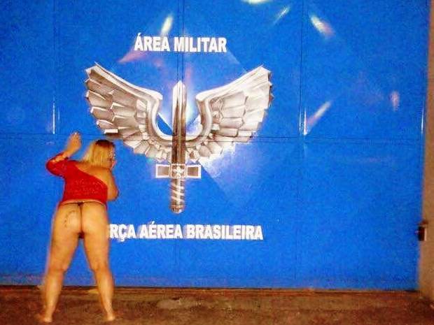 Mulher tem fotos com símbolos militares ao fundo (Foto: Reprodução/Facebook)