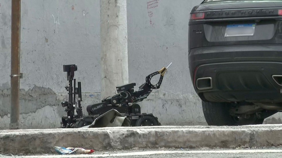 Robô da PM chegou a levar cigarro para carro onde está criminoso e casal refém — Foto: Reprodução/TV Globo