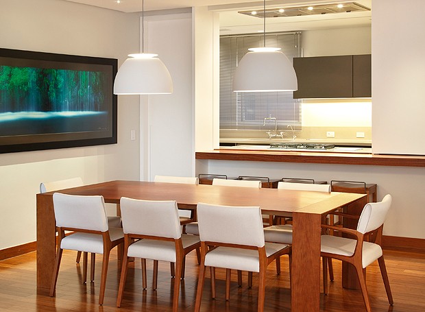 A abertura da cozinha para a sala de jantar é feita por um sistema especial de fechamento com portas de correr (Foto: MCA Estúdio)