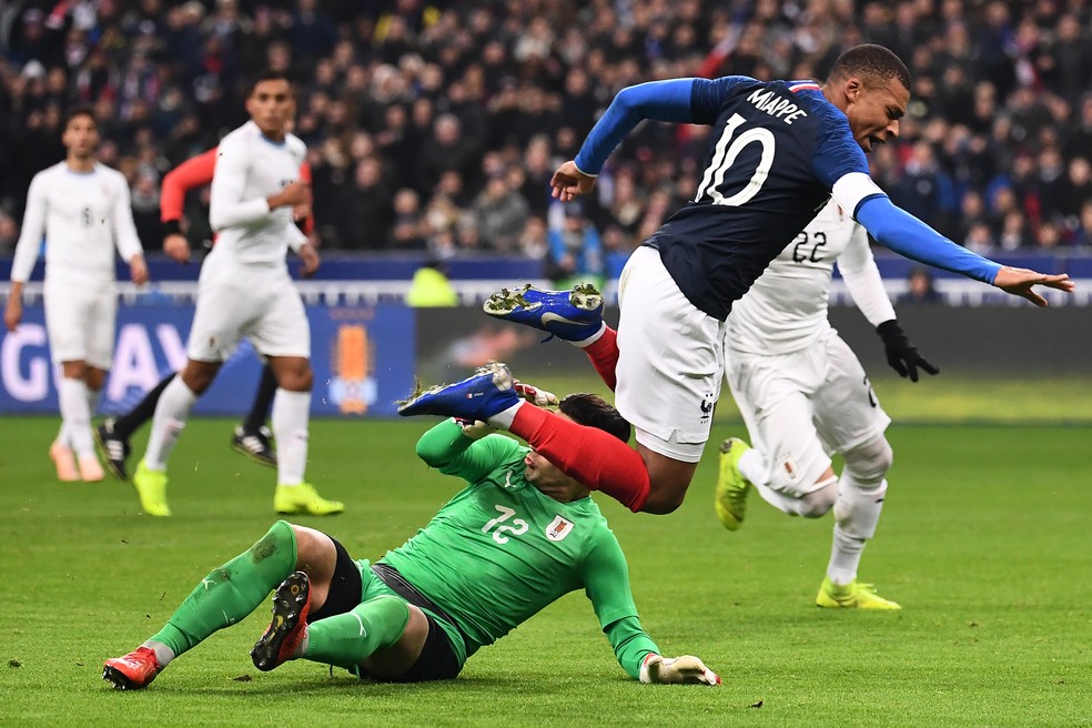 ApÃ³s a dividida, atacante voa e cai no gramado â€” Foto: Anne-Christine Poujoulat/AFP