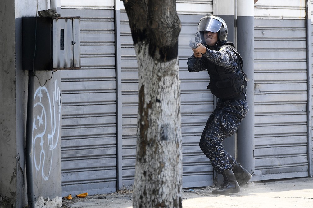 Soldado aponta sua arma contra manifestantes que pediam o fim do governo de Nicolás Maduro durante confronto em Caracas — Foto: Federico Parra/AFP