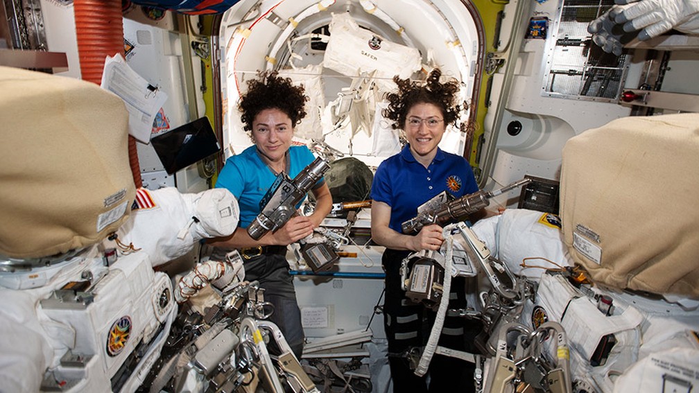 17 de outubro - As astronautas da Nasa Jessica Meir (esq.) e Christina Koch dentro da câmara Quest, preparando os trajes espaciais e as ferramentas dos EUA que usarão na primeira caminhada 100% feminina no espaço — Foto: Nasa