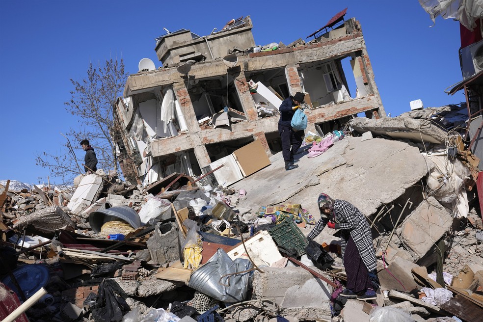Moradores em meio aos escombros em Kahramanmaras, sul da Turquia, em imagem do dia 8 de fevereiro de 2023 — Foto: Hussein Malla/Reuters