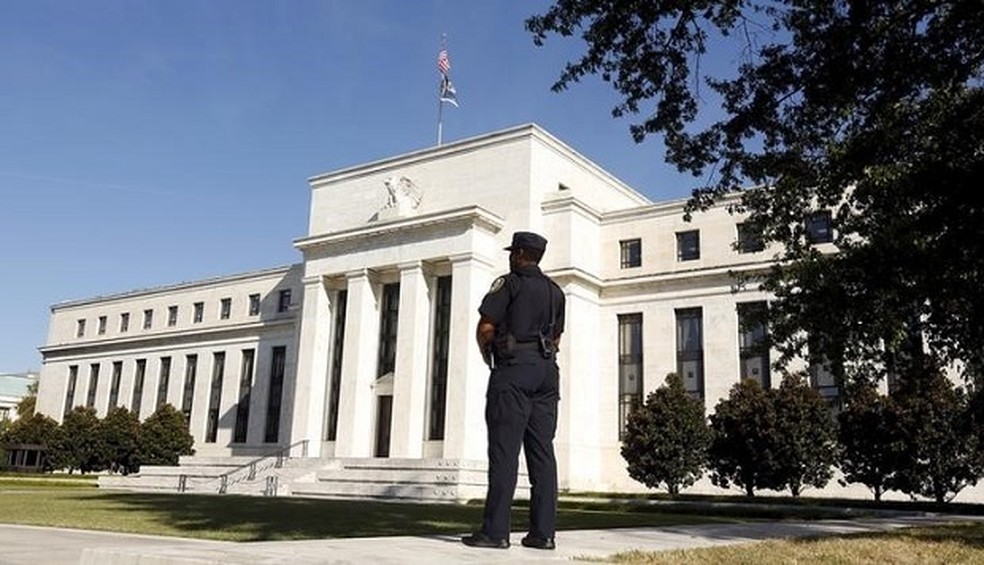 Policial observa o prédio do Federal Reserve, em Washington — Foto: Kevin Lamarque/Reuters