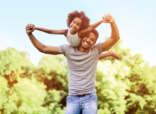 Pai e filha negros se divertem sorrindo e brincando de carregar a criança no ombro fazendo aviãozinho (Foto: Thinkstock)
