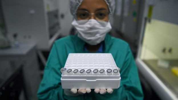 BBC - Funcionária segura amostras a serem testadas para o vírus Sars-Cov-2 na Fiocruz, onde técnicos de laboratórios de vários Estados estão sendo treinados (Foto: Carl de Souza/AFP via BBC)