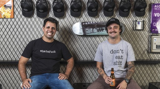 Guilherme Requião e Daniel Mocellin são fundadores da Whatafuck Hamburgueria, um estabelecimento de 26 m² em Curitiba. A ideia é oferecer lanches de qualidade e de baixo custo para os clientes, que pedem a comida e a consomem na calçada.