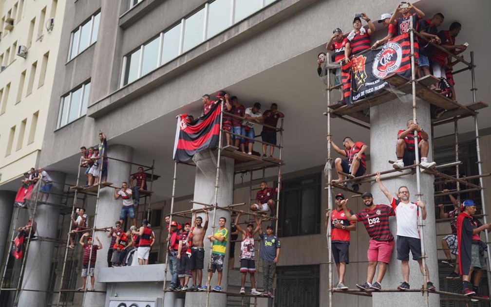 Torcedores sobem em andaime para ver passagem do time do Flamengo na Avenida Presidente Vargas neste domingo (24) — Foto: Marcos Serra Lima/G1