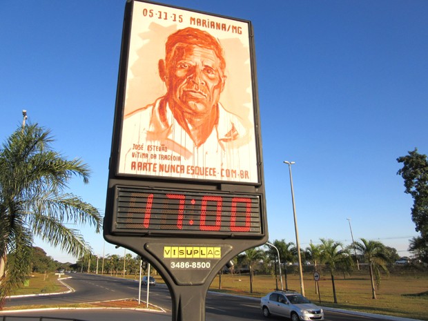 Relógio de rua estampa campanha Só a Arte Salva, com retratos de vítimas do desastre de Mariana (MG). (Foto: Alexandre Bastos/G1)
