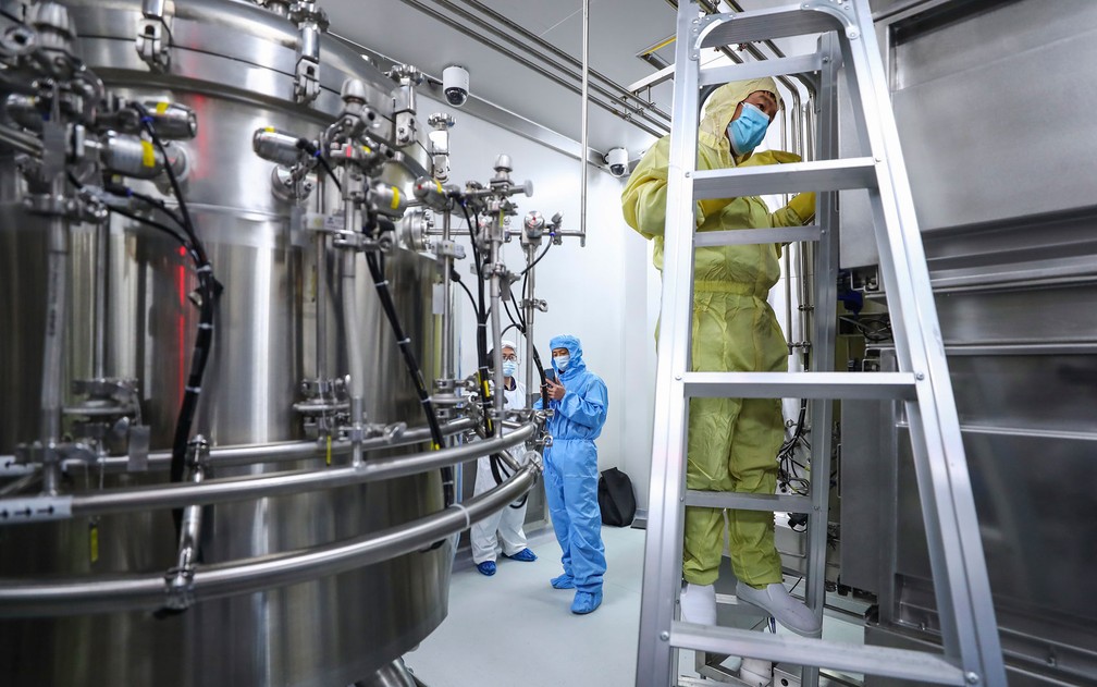 Funcionários checam e limpam equipamentos em fábrica de vacinas da SinoPharm, em Pequim, em foto de 11 de abril — Foto: Zhang Yuwei/Xinhua via AP 