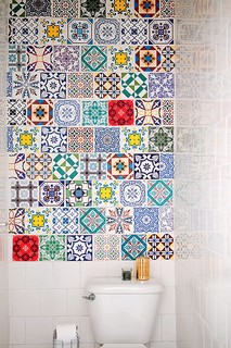 Parece um mosaico de azulejos, mas é um tecido adesivo para a parede. Ele aqueceu o banheiro branco