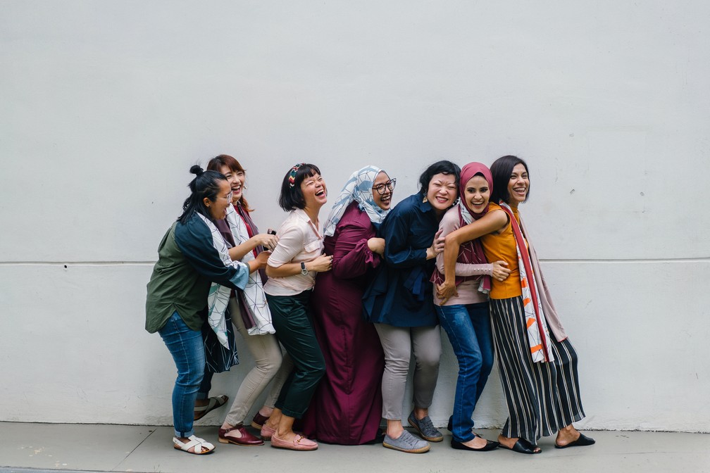 Foto mostra mulheres dando risada e se abraçando enquanto posam para foto.  — Foto: Pexels