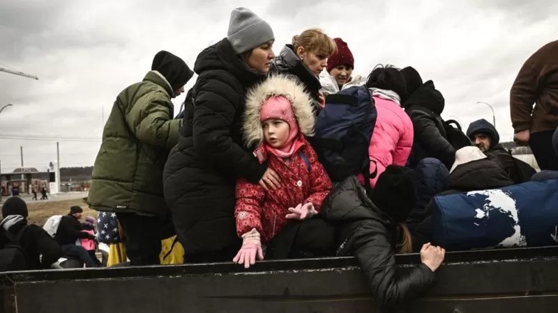 Uma criança observa enquanto os moradores evacuam a cidade de Irpin, a noroeste de Kiev, em 5 de março de 2022 (Foto: Getty Images via BBC)