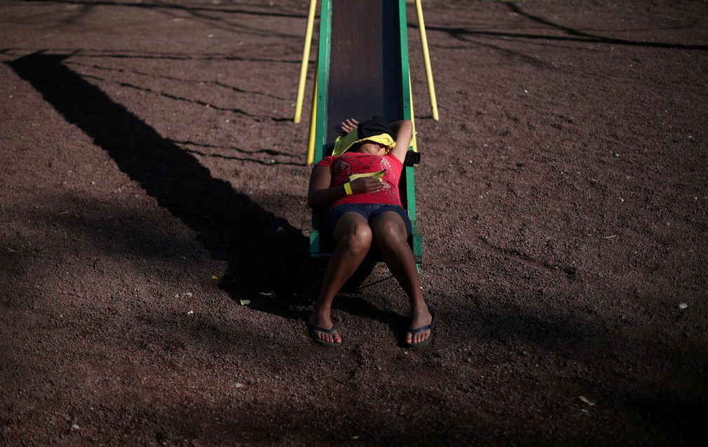 Migrante descansa em um escorregador em abrigo na Cidade do México — Foto: Hannah McKay/Reuters