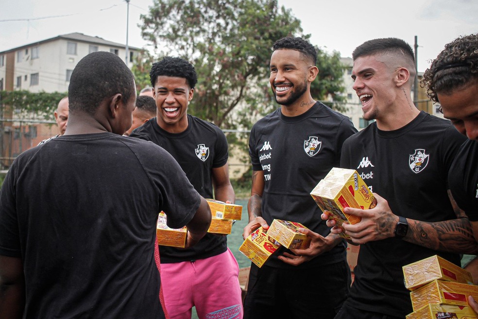 Jogadores do Vasco distribuem chocolates na Cidade de Deus — Foto: Matheus Lima / CRVG