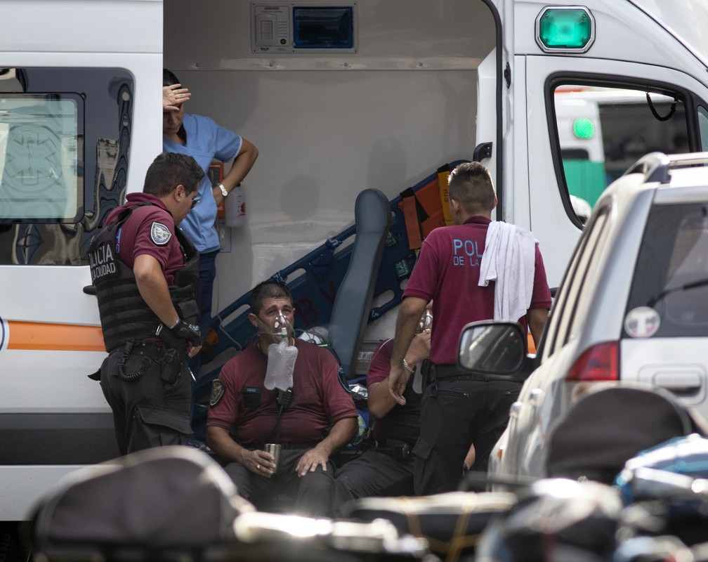 Policiais são atendidos em ambulância durante resgate em incêndio de hotel no centro de Buenos Aires, na Argentina — Foto: Damian Dopacio / NOTICIAS ARGENTINAS / AFP