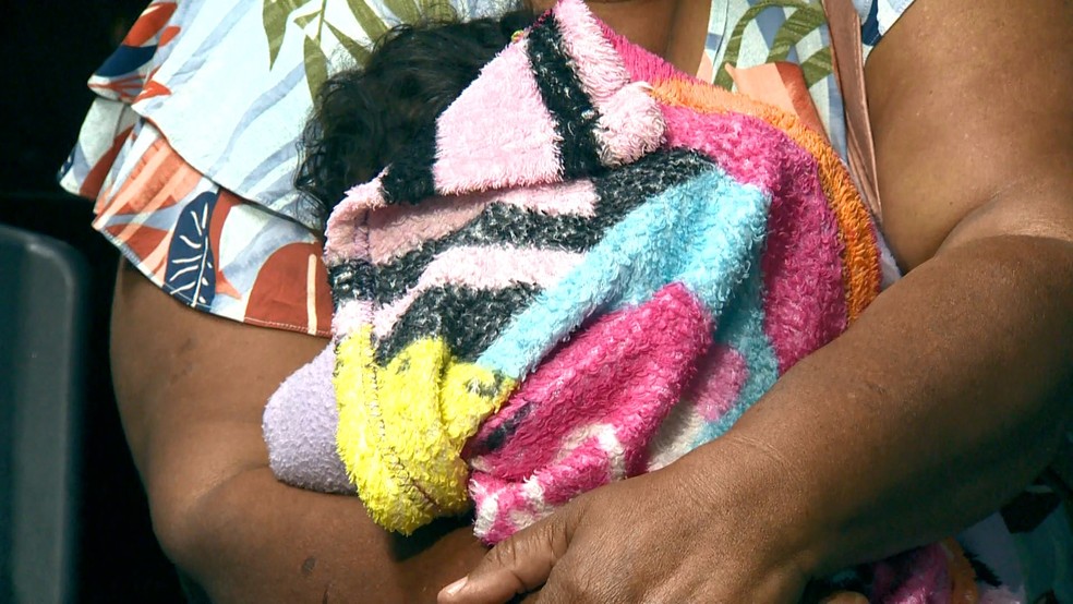 Menina de oito meses que foi agredida pela mãe estava no colo da avó na Delegacia Regional da Serra — Foto: Reprodução/TV Gazeta